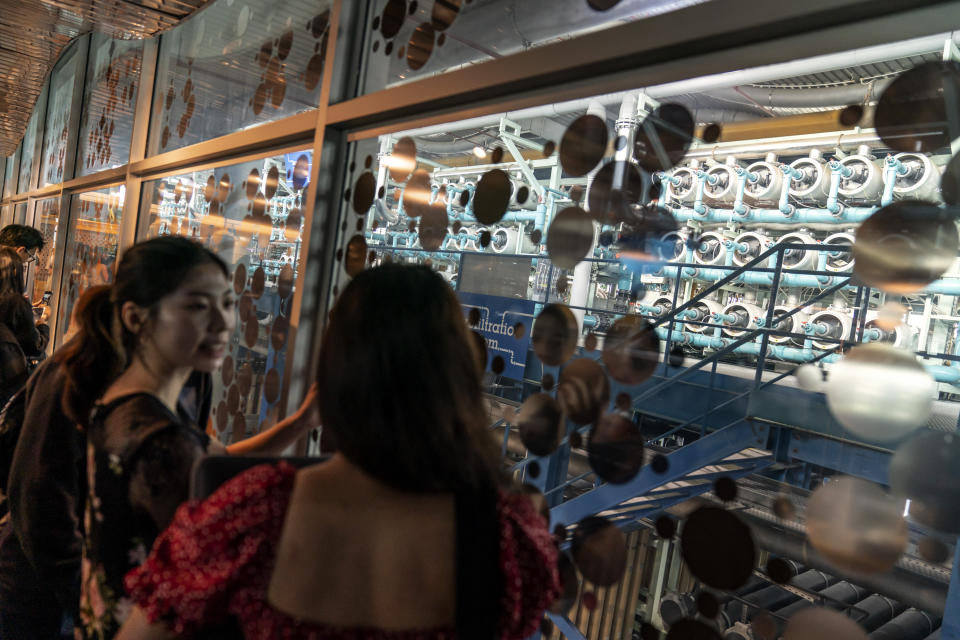 A youth group tours the micro filtration system at the NEWater visitor center in Singapore, Tuesday, July 18, 2023. At the NEWater processing facility, visitors can walk through mock tunnels, see inside of filters and answer quizzes on ways they can better reduce their own water use while being able to watch water quality checks in real-time. (AP Photo/David Goldman)