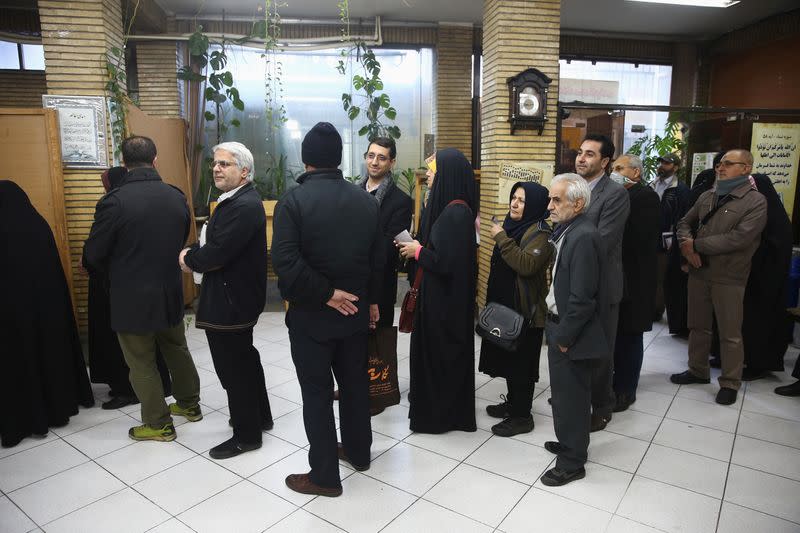 Iranians wait in line to vote at a polling station during parliamentary elections in Tehran,
