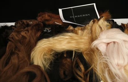 A selection of wigs lie on a table backstage before the Burberry Prorsum Autumn/Winter 2014 collection presentation during London Fashion Week February 17, 2014. REUTERS/Suzanne Plunkett