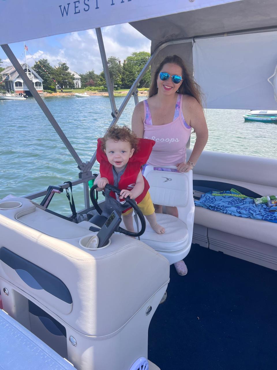 James "Jimmy" Tyler Brown, an 18-month-old, checks out the steering power in early July with his mother, Sierra Brown, of Sea Scoops of West Falmouth.