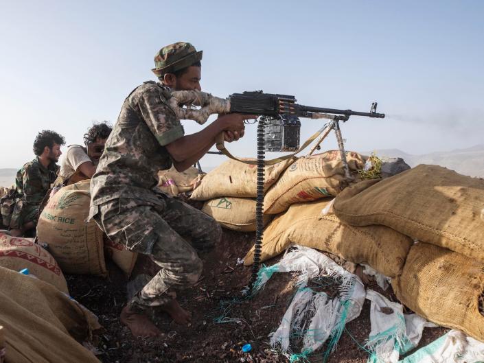 A Yemeni fighter backed by the Saudi-led coalition fires his weapon during clashes with Houthi rebels on the Kassara frontline near Marib, Yemen, June 20, 2021.