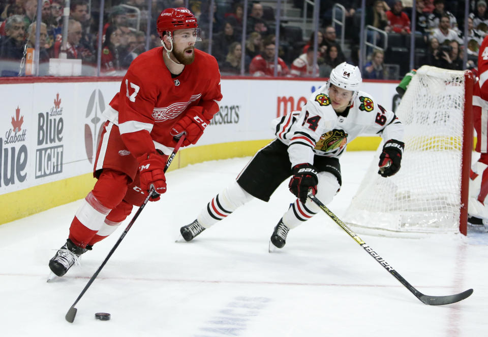 Detroit Red Wings defenseman Filip Hronek (17) is guarded by Chicago Blackhawks center David Kampf (64) during the first period of an NHL hockey game Friday, March 6, 2020, in Detroit. (AP Photo/Duane Burleson)