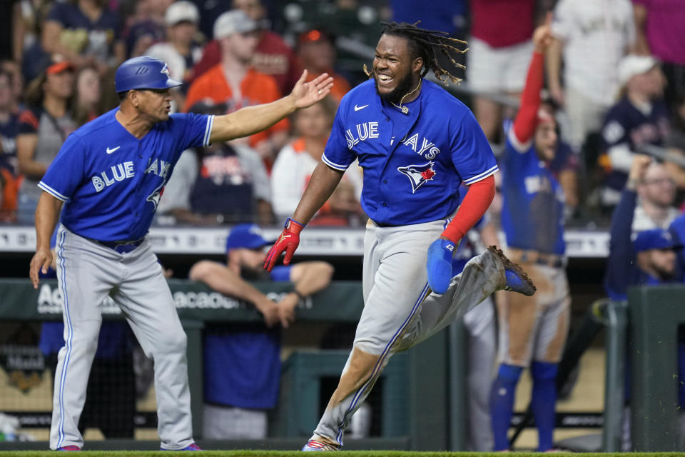 Toronto Blue Jays' Vladimir Guerrero Jr., right, runs home to score on Matt Chapman's RBI double during the ninth inning of the team's baseball game against the Houston Astros, Friday, April 22, 2022, in Houston. (AP Photo/Eric Christian Smith)