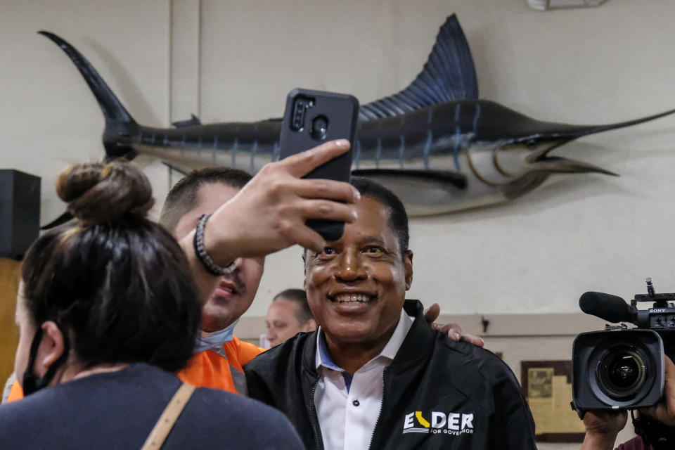 Republican conservative radio show host Larry Elder takes photos with patrons when he visiting Philippe The Original Deli during a campaign for the California gubernatorial recall election on Monday, Sept. 13, 2021, in Los Angeles. (AP Photo/Ringo H.W. Chiu)