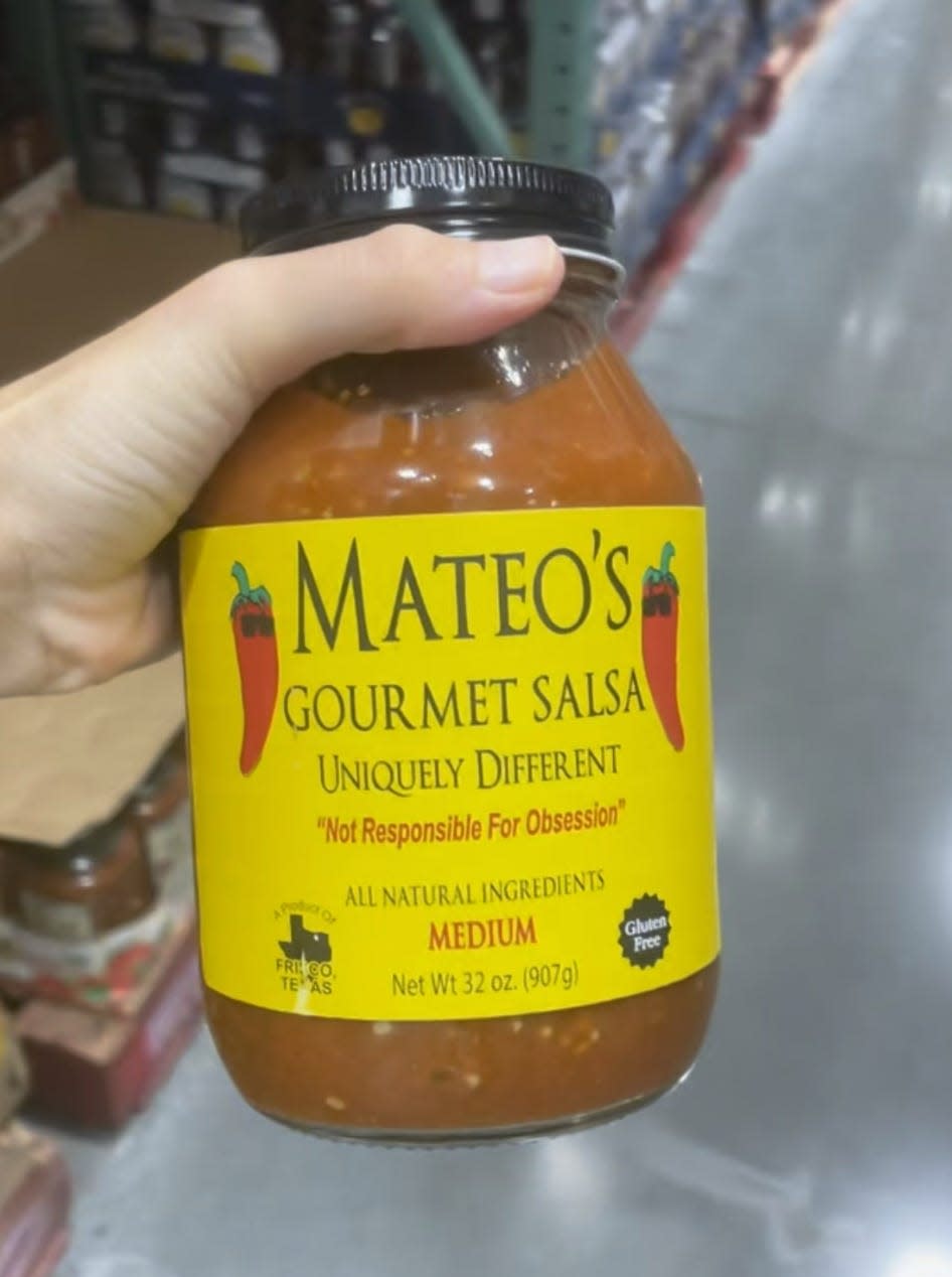 hand holding jar of salsa at costco