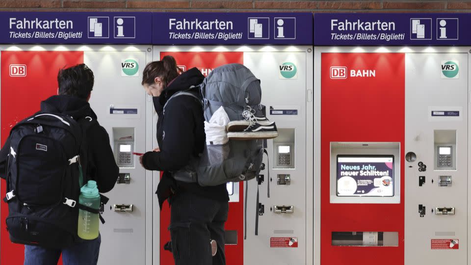 Travelers seek information at a Deutsche Bahn ticket machine in Cologne's main railway station. - Andreas Rentz/Getty Images