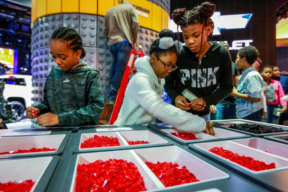 Michael Dowe, 10; from the left, Sarah Evans, 10 and Akyah Burell, 12, all of Detroit builda prototype at the LEGO Silverado build station, during the start of the North American International Auto Show at Cobo Center in downtown Detroit on Saturday, Jan. 19, 2019.