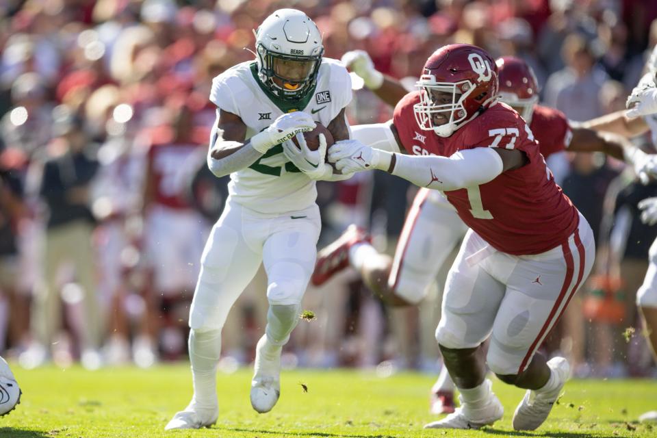 Baylor’s Richard Reese (29) runs the ball and is brought down by Oklahoma’s Jeffery Johnson (77) in the first quarter of the Bears' 38-35 win Saturday in Norman.