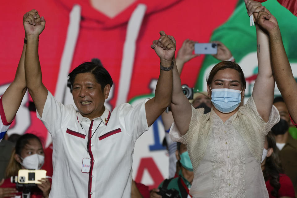 FILE - Presidential candidate, Ferdinand Marcos Jr., the son of the late dictator, left, raises arms with running mate Davao City Mayor Sara Duterte, the daughter of the current President, during their last campaign rally Saturday, May 7, 2022, in Paranaque city, Philippines. Marcos Jr. and Duterte are the new leaders of the Philippines, an alliance that ushers in six years of governance that has some human rights activists concerned about the course their country may take with the pair in power. (AP Photo/Aaron Favila, File)