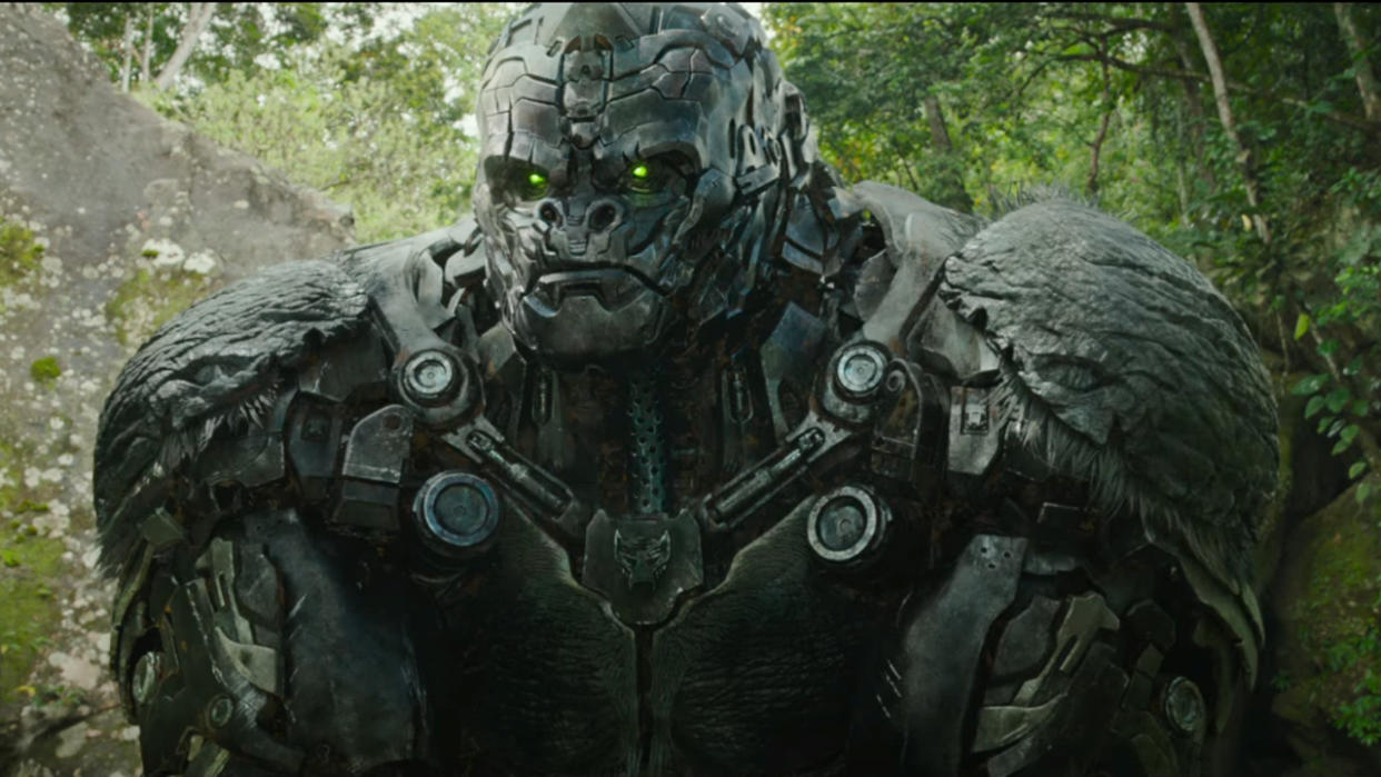  Optimus Primal sitting stoically in the jungle in Transformers Rise of the Beasts. 