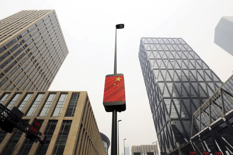 A Chinese national flag is seen among buildings at the Yujiapu financial centre, in Tianjin