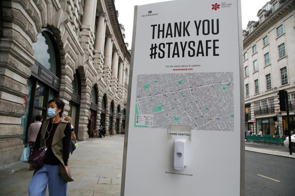  A woman wearing a face mask walks past a hand sanitizer station at Regents Street during coronavirus pandemic. It is mandatory to wear face masks while travelling. (Photo by Dinendra Haria / SOPA Images/Sipa USA) 