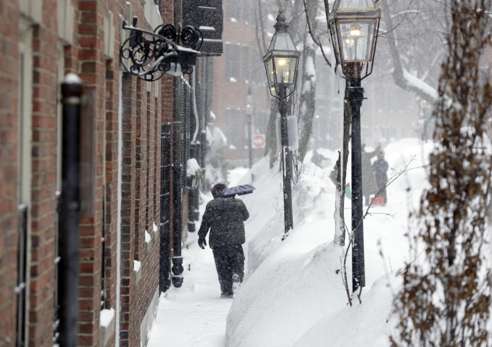 FILE - A snow shoveler walks along a snow-covered sidewalk, Monday, Feb. 9, 2015, in Boston. For much of the Eastern United States, the winter of 2023 has been a bust. Snow totals are far below average from Boston to Philadelphia in 2023 and warmer temperatures have often resulted in more spring-like days than blizzard-like conditions. (AP Photo/Steven Senne, File)