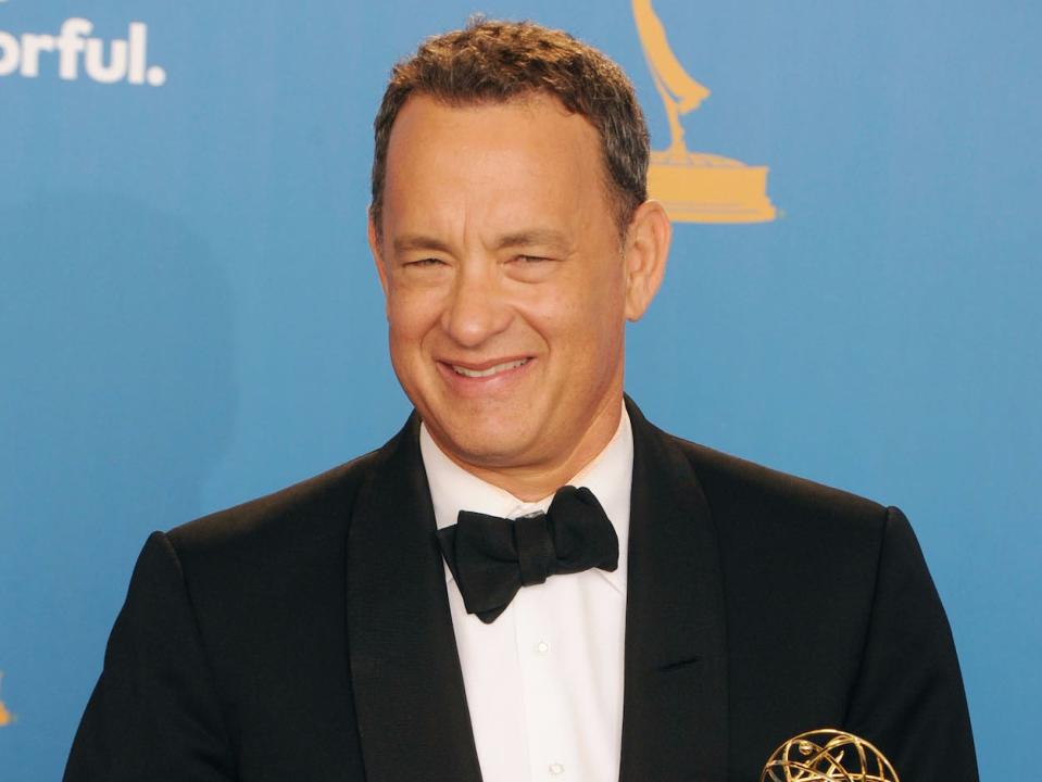 Tom Hanks wears a tuxedo and smiles