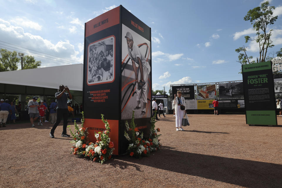 Flowers are seen at the base of a tribute to Willie Mays is seen outside Rickwood Stadium before the start of a baseball game between the St. Louis Cardinals and the San Francisco Giants Thursday, June 20, 2024, in Birmingham, Ala. Mays, who began his professional career with the Birmingham Black Barons of the Negro Leagues in 1948 and played at Rickwood Field, passed away on Tuesday at the age of 93. (AP Photo/Vasha Hunt)