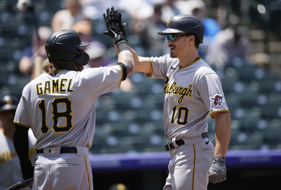 Pittsburgh Pirates' Ben Gamel, left, congratulates Bryan Reynolds as he crosses home plate after hitting a solo home run off Colorado Rockies starting pitcher Jon Gray in the first inning of a baseball game Wednesday, June 30, 2021, in Denver. (AP Photo/David Zalubowski)