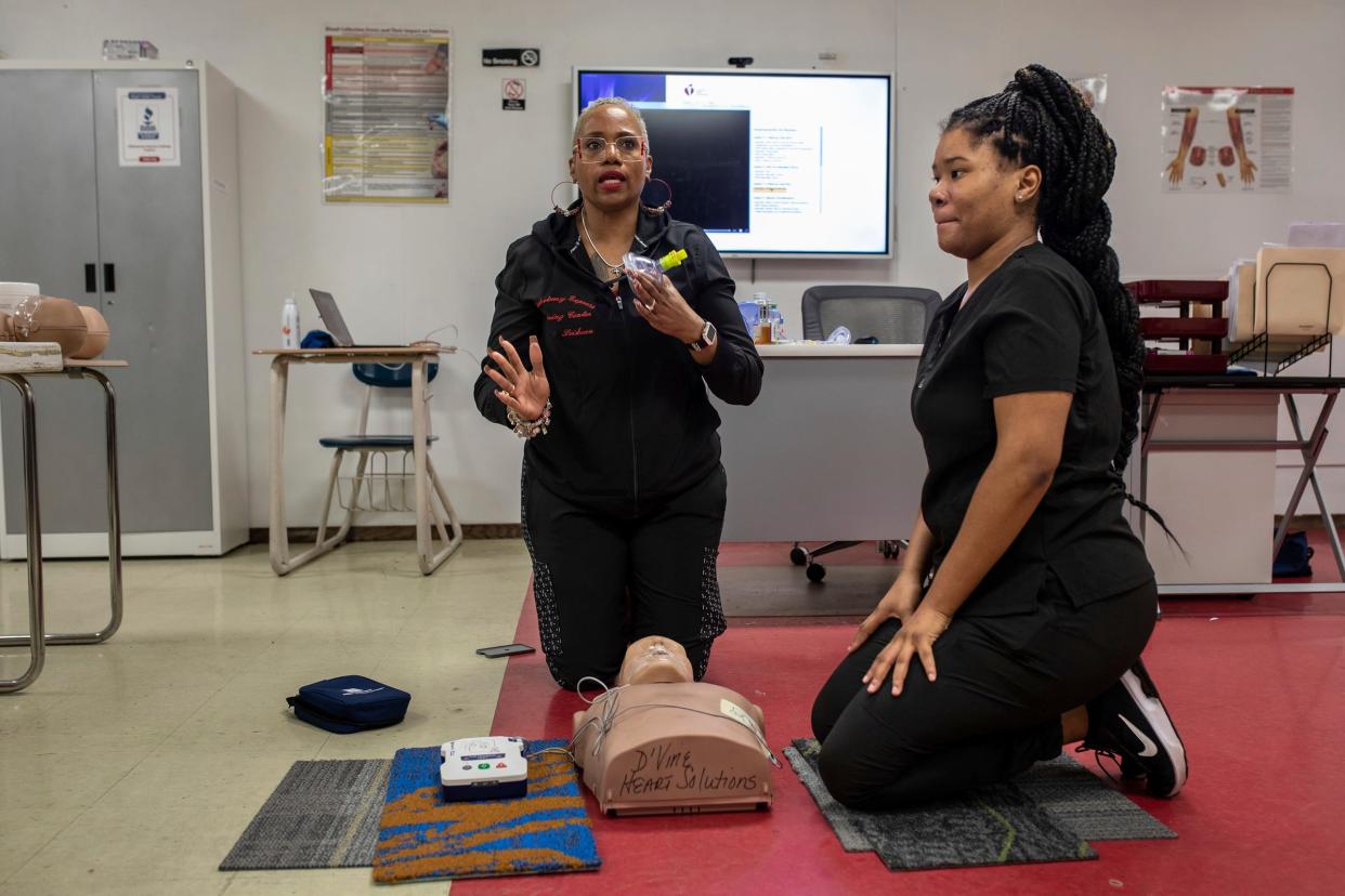 Lei Sean Curtis, 55, an MPH and CPI-certified American Heart Association instructor, helps a student, Nahyja Brown, 24, during a CPR lesson inside the Phlebotomy Express Training Centers in Detroit on Tuesday, March 12, 2024.