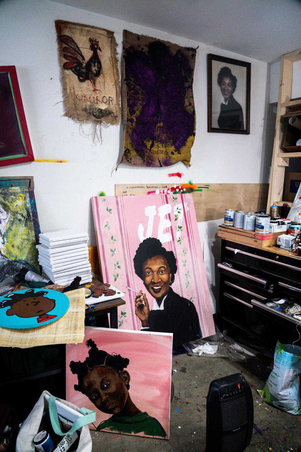 Paintings by Robert Moore, including a Jet Magazine cover featuring his grandmother (center) sit in his studio.