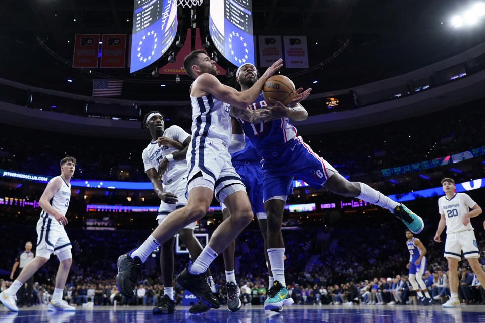 Philadelphia 76ers' Buddy Hield, right, and Memphis Grizzlies' John Konchar struggle for a loose ball during the first half of an NBA basketball game, Wednesday, March 6, 2024, in Philadelphia. (AP Photo/Matt Slocum)