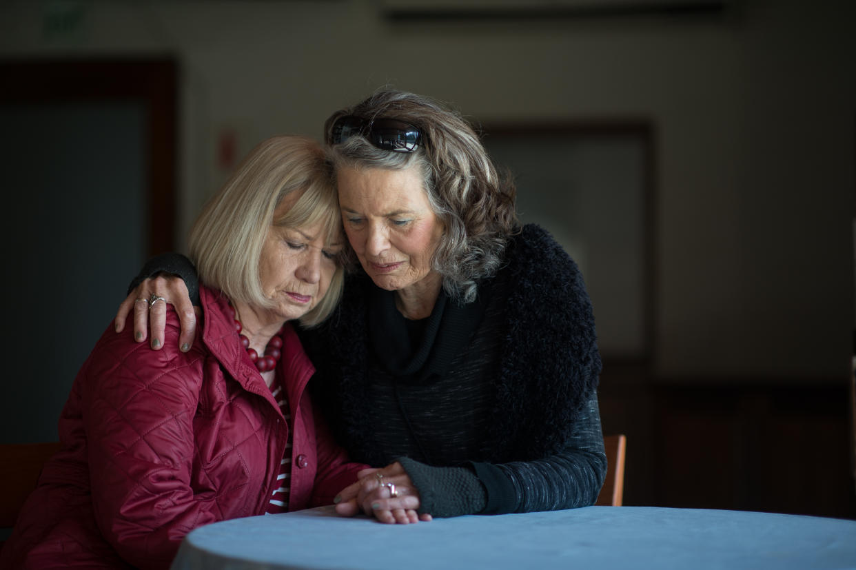 A senior lady supporting her friend after receiving sad bad news by holding hands comforting words and hugging her in support Stellenbosch Cape Town South Africa