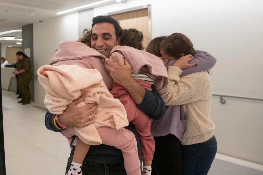 Aviv Asher, 2,5-year-old, her sister Raz Asher, 4,5-year-old, and mother Doron, react as they meet with Yoni, Doron’s husband and their father, after they returned to Israel to the designated complex at the Schneider Children’s Medical Center on Friday, Nov. 24, 2023. A four-day cease-fire in the Israel-Hamas war began in Gaza on Friday with an exchange of hostages and prisoners. (Schneider Children’s Medical Center via AP)