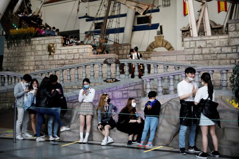 FILE PHOTO: People wearing protective face masks to avoid the spread of the coronavirus disease (COVID-19), wait in a line at an amusement park in Seoul