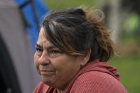 Laura Gutowski tears up while speaking to the Associated Press, Saturday, March 23, 2024, at Fruidale Park in Grants Pass, Ore. Gutowski's life was upended when her husband died from a pulmonary embolism. Suddenly, in her 50s, she found herself with no income. They didn't have life insurance or savings, and about a month after his passing, she was sleeping outside in the city she grew up in. "I used to love camping," she said through tears. "I loved the outdoors. And now I can't stand it anymore." (AP Photo/Jenny Kane)