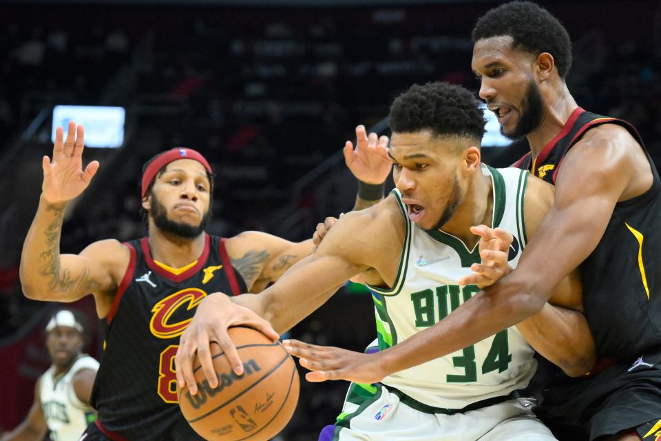 Cleveland Cavaliers forwards Lamar Stevens and Evan Mobley (left) defend  Bucks forward Giannis Antetokounmpo in the third quarter Wednesday night.