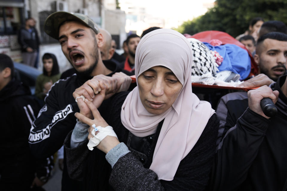 Relatives carry the body of a Palestinian militant during his funeral in Tulkarem, West Bank, Tuesday, Jan. 9, 2023. Three militants were killed in clashes during an Israeli forces raid on Iktaba, near Tulkaerm, on Monday night. (AP Photo/Majdi Mohammed)