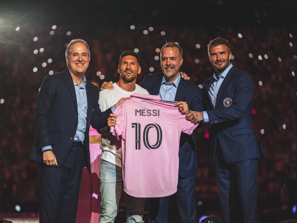 Jorge Mas, Lionel Messi, Jose Mas, David Beckham, hold a pink Inter Miami jersey with Messi's name on at the player's unveiling