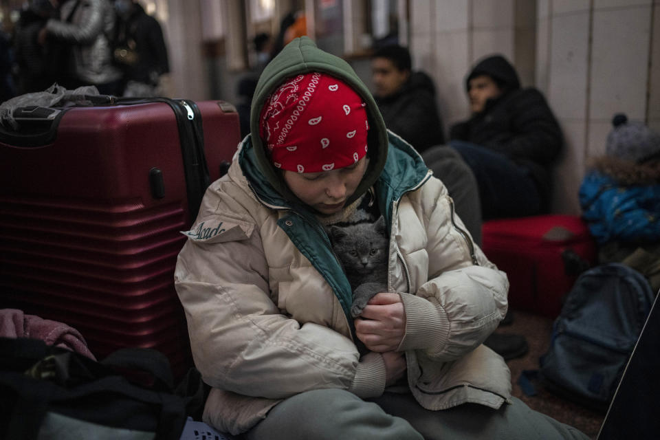 A Ukrainian girl pets her cat in her coat inside Lviv railway station, Monday, Feb. 28, 2022, in Lviv, west Ukraine. (AP Photo/Bernat Armangue)