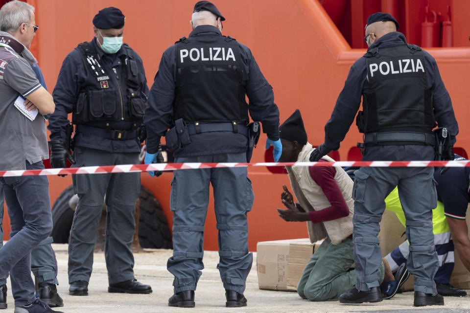 A man knees as he disembarks from the Asso Trenta ship, docked in the port of Pozzallo, Italy, Sunday, Nov. 3, 2019. An Italian offshore supply vessel has brought 151 migrants to Sicily after rescuing them in waters off Libya a day earlier. (Francesco Ruta/ANSA via AP)
