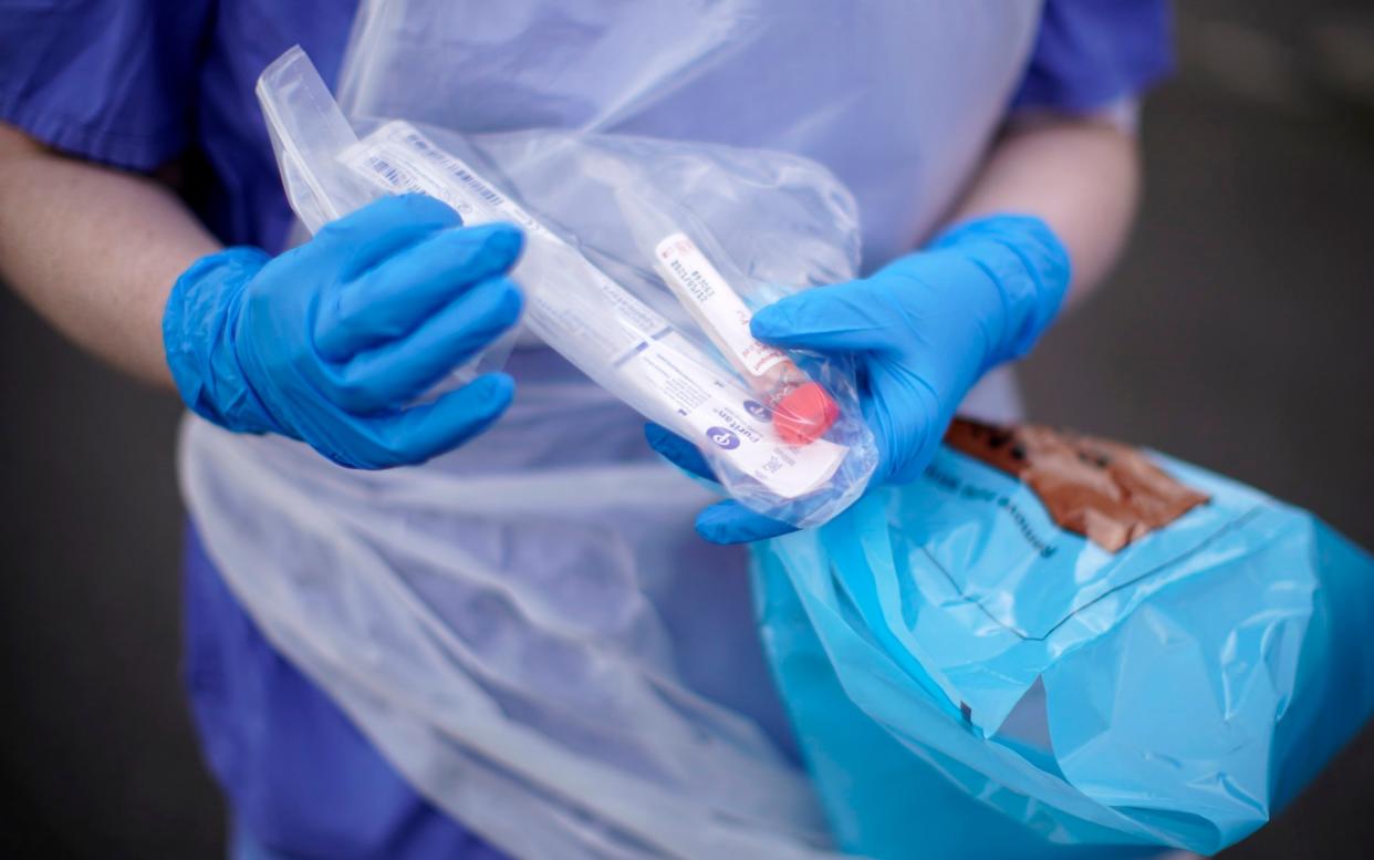 An NHS nurse holds a coronavirus testing kit at a drive-through testing site in Wolverhampton - Getty