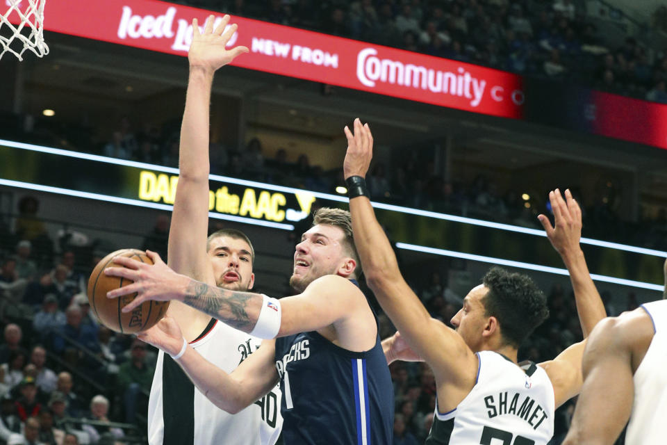 Dallas Mavericks forward Luka Doncic (77) goes up for a shot against Los Angeles Clippers center Ivica Zubac (40) and guard Landry Shamet (20) during the first half of an NBA basketball game Tuesday, Jan. 21, 2020 in Dallas. (AP Photo/Richard W. Rodriguez)