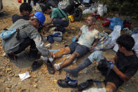 Turkish volunteers rest as they fight wildfires in Turgut village, near tourist resort of Marmaris, Mugla, Turkey, Wednesday, Aug. 4, 2021. As Turkish fire crews pressed ahead Tuesday with their weeklong battle against blazes tearing through forests and villages on the country's southern coast, President Recep Tayyip Erdogan's government faced increased criticism over its apparent poor response and inadequate preparedness for large-scale wildfires.(AP Photo/Emre Tazegul)