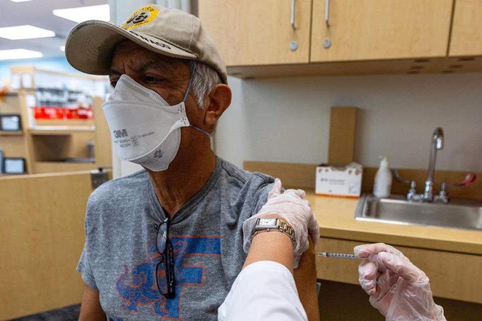 CVS Health Pharmacy Manager Aylen Amestoy administers the newest COVID-19 vaccine shot to Sasan Sowlati, 71, at a CVS in Miami, Florida, on Thursday, September 14, 2023.