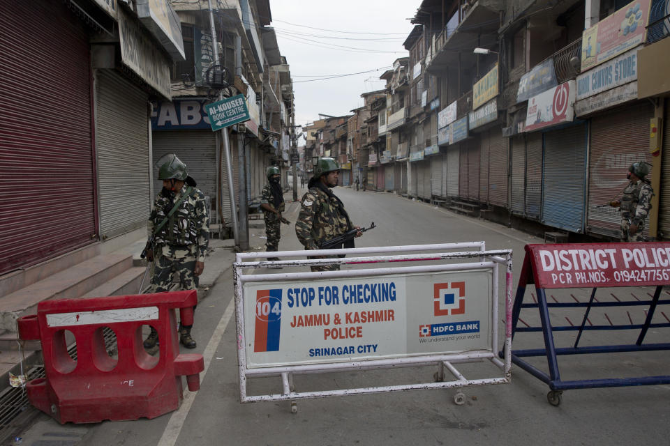 In this Tuesday, Aug. 6, 2019 photo, Indian Paramilitary soldiers stand guard during curfew in Srinagar, Indian controlled Kashmir, Wednesday, Aug. 7, 2019. Authorities in Hindu-majority India clamped a complete shutdown on Kashmir as they scrapped the Muslim-majority state's special status, including exclusive hereditary rights and a separate constitution, and divided it into two territories. (AP Photo/Dar Yasin)