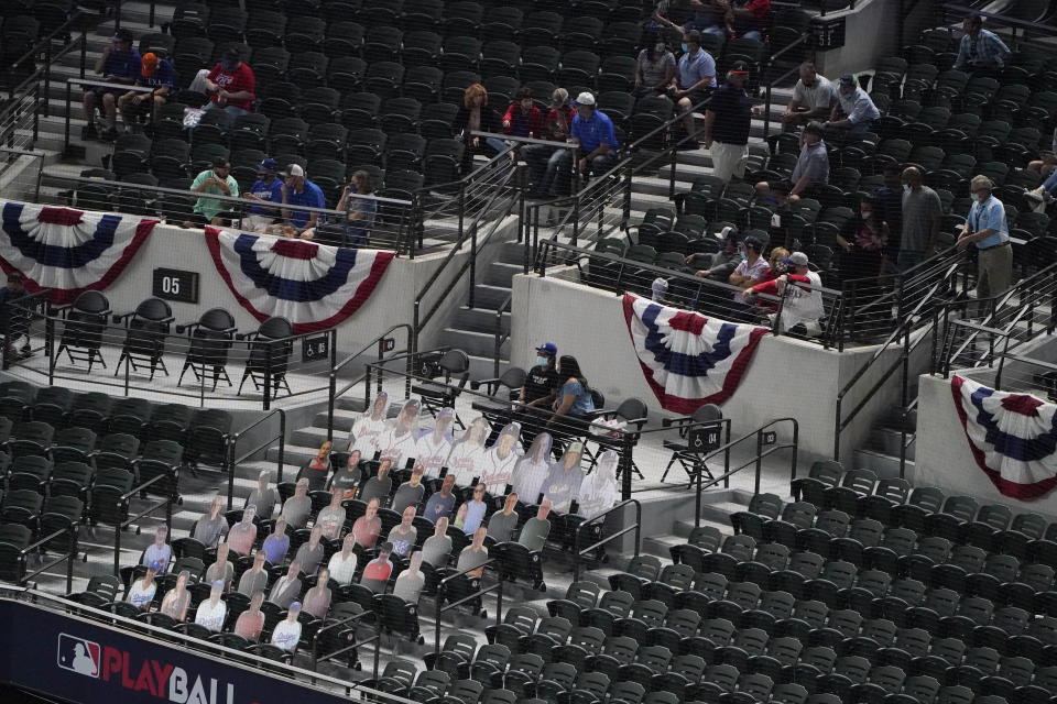 Fans watch near a section of cardboard cutouts during the second inning in Game 1 of a baseball National League Championship Series between the Los Angeles Dodgers and the Atlanta Braves Monday, Oct. 12, 2020, in Arlington, Texas. (AP Photo/Sue Ogrocki)