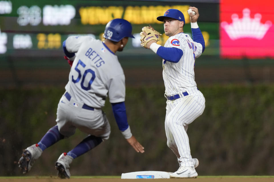 Chicago Cubs second baseman Nico Hoerner, right, throws out Los Angeles Dodgers' Austin Barnes at first after forcing out Mookie Betts at second during the seventh inning of a baseball game in Chicago, Thursday, April 20, 2023. (AP Photo/Nam Y. Huh)