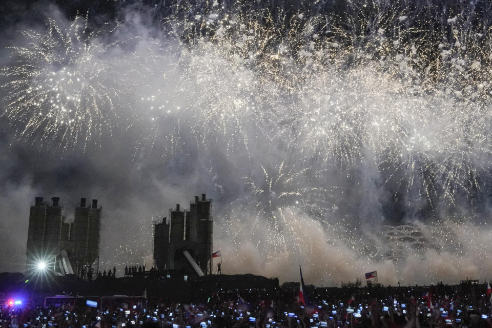 Supporters hold Philippine flags during a fireworks display at the last campaign rally known as "Miting De Avance" for presidential candidate, Ferdinand Marcos Jr., the son of the late dictator, and his team on May 7, 2022 in Paranaque city, Philippines. The winner of May 9, Monday's vote will inherit a sagging economy, poverty and deep divisions, as well as calls to prosecute outgoing leader Rodrigo Duterte for thousands of deaths as part of a crackdown on illegal drugs. (AP Photo/Aaron Favila)