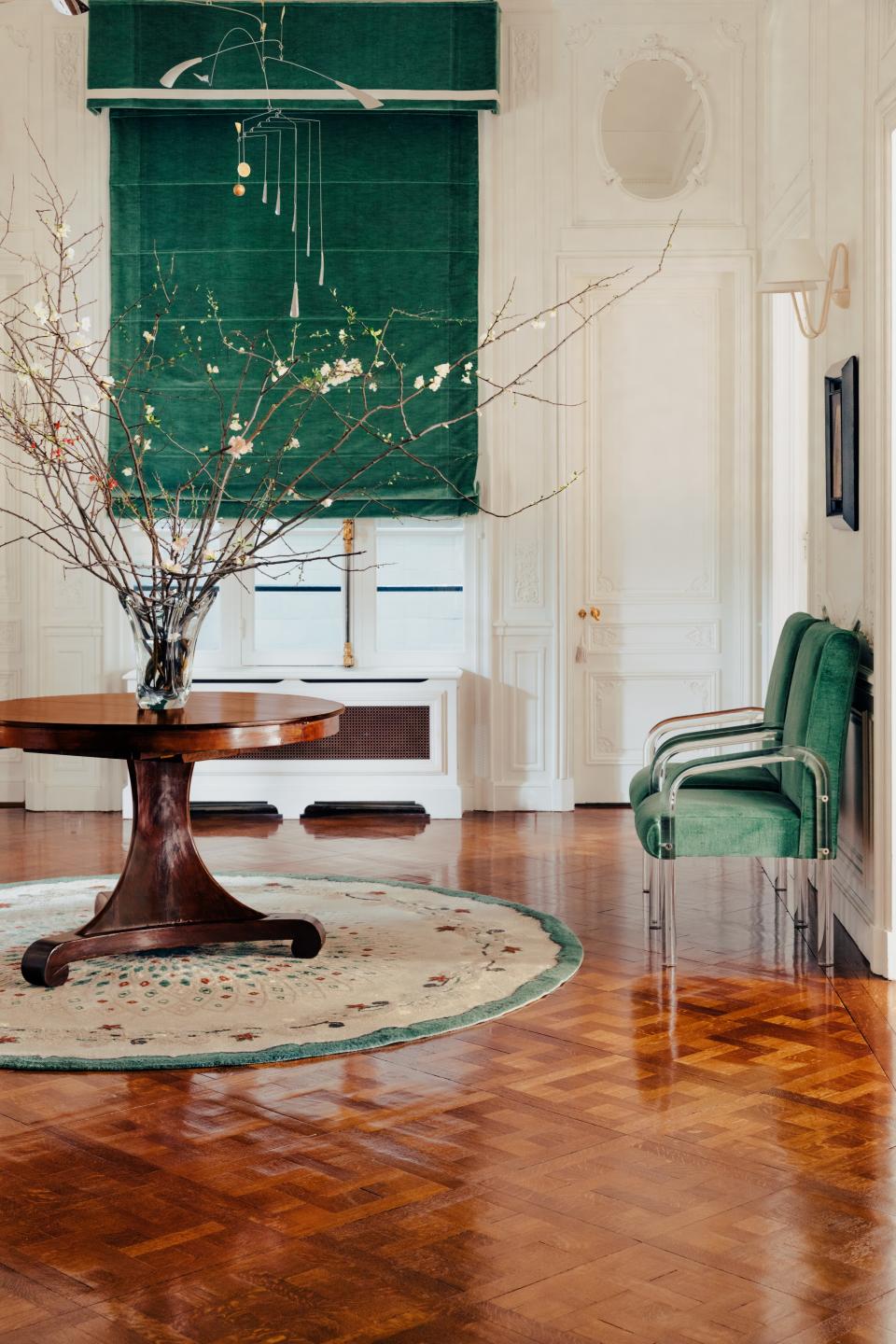 A Claude Kintzler mobile hangs in a hall whose shade and valance are made of a Clarence House fabric. 1930s table; Maison Leleu rug; Jean Royère sconce.