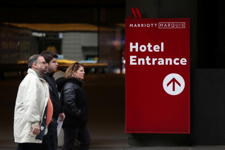 Des gens marchent près de l'hôtel Marriott Marquis à Manhattan, New York, États-Unis, le 23 mars 2022. REUTERS/Andrew Kelly