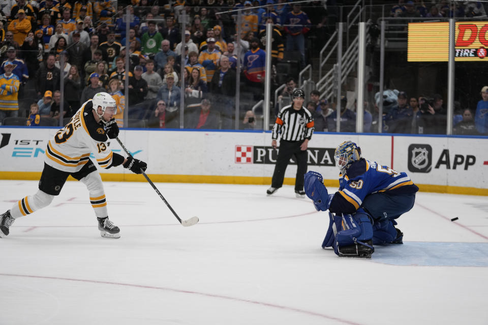 Boston Bruins' Charlie Coyle (13) scores past St. Louis Blues goaltender Jordan Binnington during a shootout of an NHL hockey game Sunday, April 2, 2023, in St. Louis. (AP Photo/Jeff Roberson)