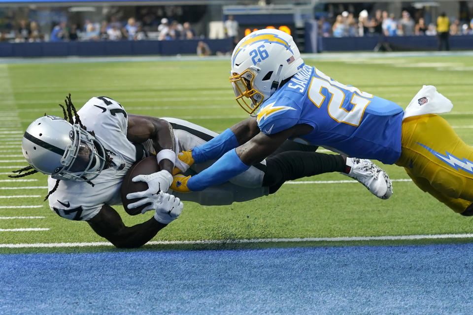 Las Vegas Raiders wide receiver Davante Adams, left, scores a touchdown against Los Angeles Chargers cornerback Asante Samuel Jr. (26) during the second half of an NFL football game in Inglewood, Calif., Sunday, Sept. 11, 2022. (AP Photo/Marcio Jose Sanchez)