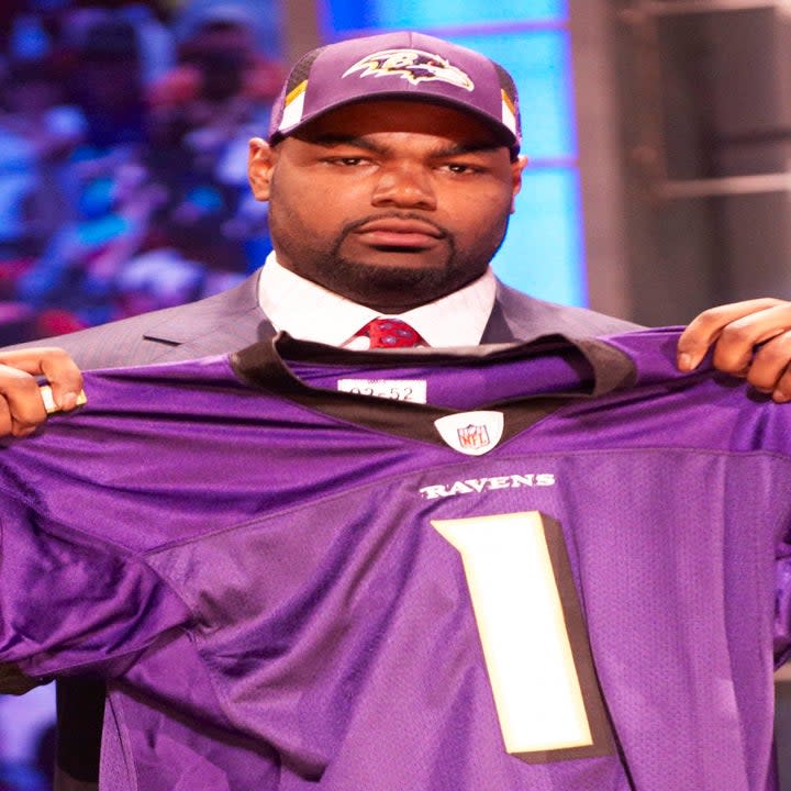 Closeup of Michael Oher holding up a Ravens jersey