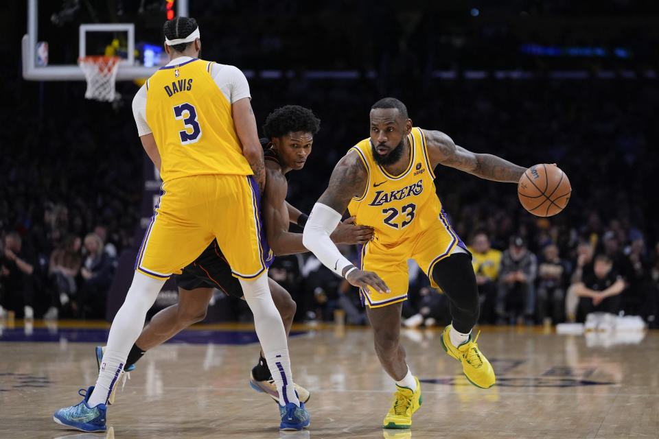 Los Angeles Lakers forward LeBron James, drives past a screen set by forward Anthony Davis, left, against Detroit Pistons forward Ausar Thompson during the second half of an NBA basketball game Tuesday, Feb. 13, 2024, in Los Angeles. (AP Photo/Ryan Sun)