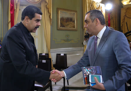 El presidente venezolano (I), Nicolás Maduro, y el presidente del Tribunal Supremo de Justicia, Maikel Moreno, estrechan sus manos durante una reunión en el Palacio de Miraflores en Caracas, Venezuela, 1 de abril del 2017. Foto tomada el 31 de marzo del 2017. Palacio de Miraflores/Handout via REUTERS