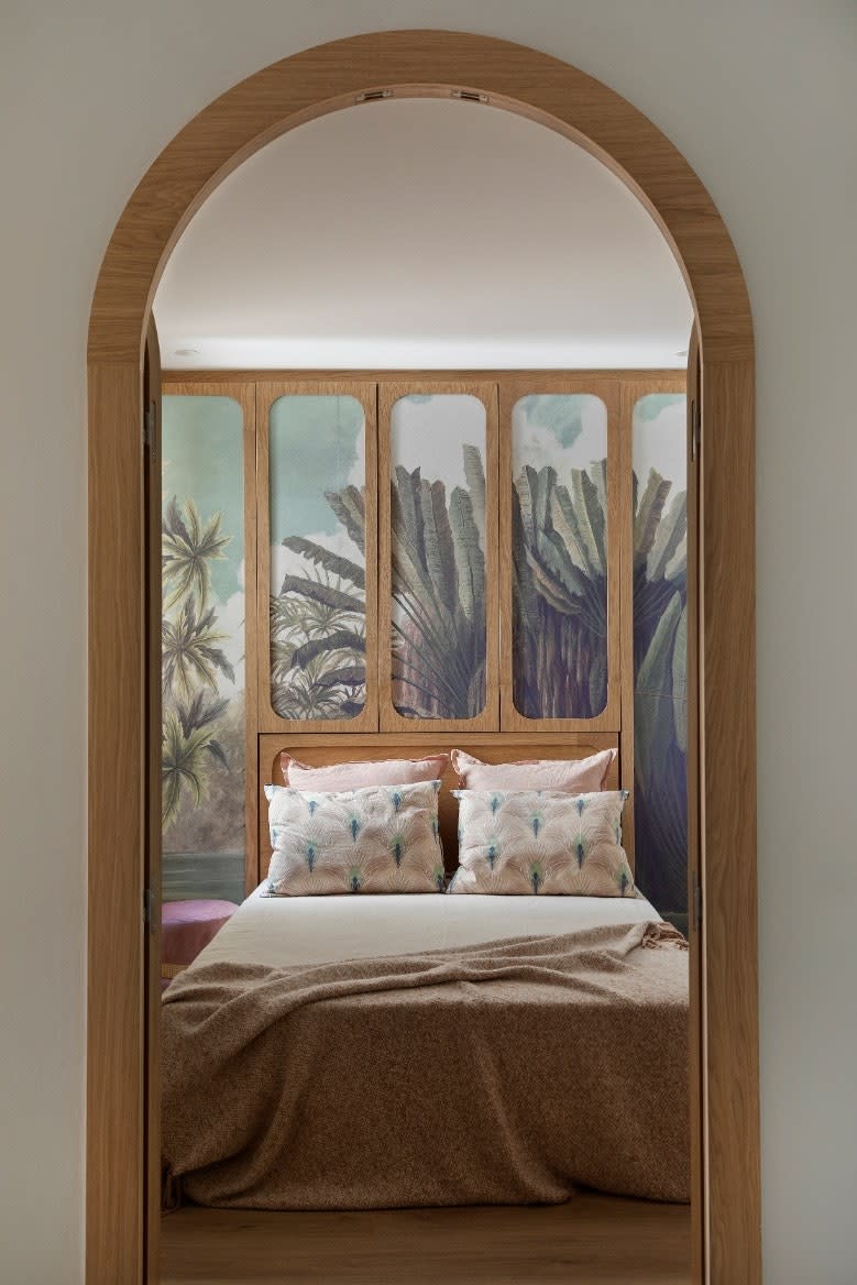 The tropical wallpaper by Ananbô contrasts with the wooden doors by Noé Prades Studio.