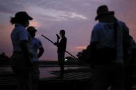 A man holds a mobile phone as immigration agents stand by the bank of the Suchiate River, while they guard the border with the National Guard to prevent a migrant caravan of Central Americans from entering, in Ciudad Hidalgo