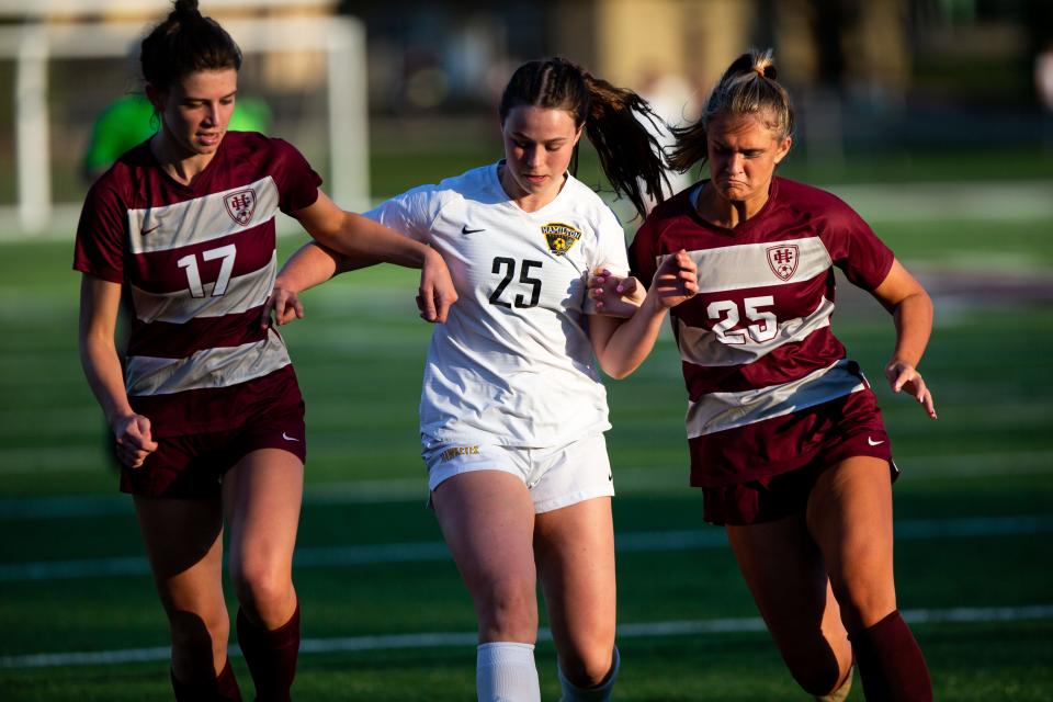 Hamilton's Mariana DellaVecchia fights for posession against Holland Christian's Sierra Malone (left) and Ellen Wierda (right) Wednesday, April 12, 2023, at Holland Christian. 